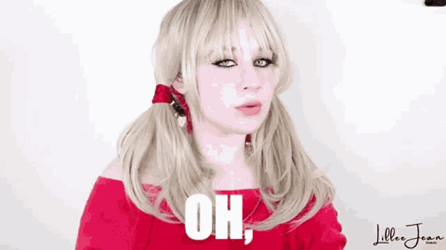 a woman with blonde hair and pigtails is wearing a red off the shoulder top and says oh .