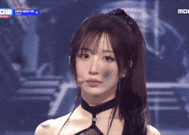 a girl with a ponytail is on a stage with the words know about me on the screen