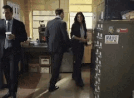 a man in a suit and tie is standing next to a woman in a suit and tie