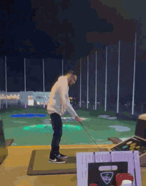 a man swings a golf club on a driving range