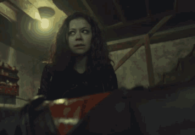 a woman in a dark room is holding a bag that says m & m 's