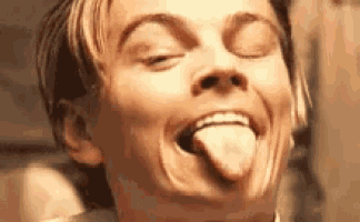 a man is sticking his tongue out and smiling .