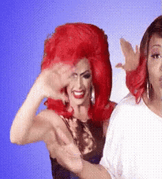 a drag queen with red hair is standing next to a woman with a white shirt .