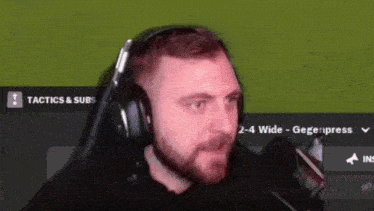 a man wearing headphones is sitting in front of a screen that says tactics & subs .
