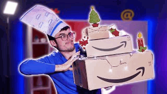 a man is holding a stack of amazon boxes with a christmas tree on top .