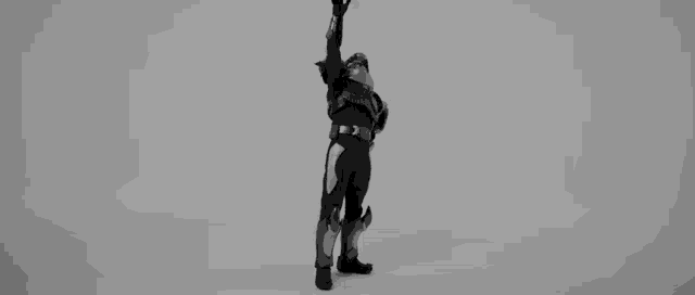 a black and white photo of a superhero holding a sword