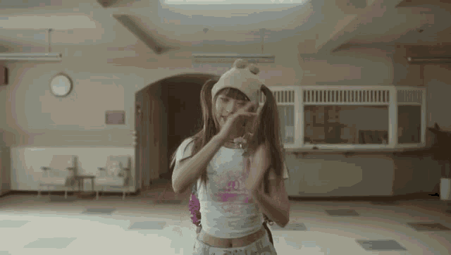 a girl with pigtails wearing a bear hat and a crop top that says ' i love you ' on it
