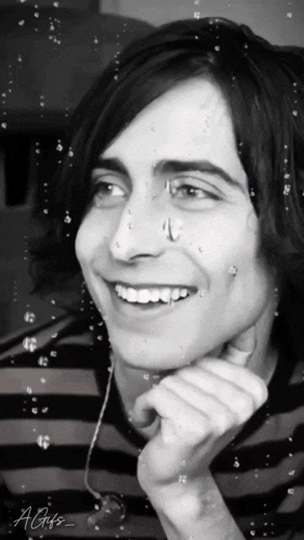 a black and white photo of a smiling young man with the letters agifs on the bottom right