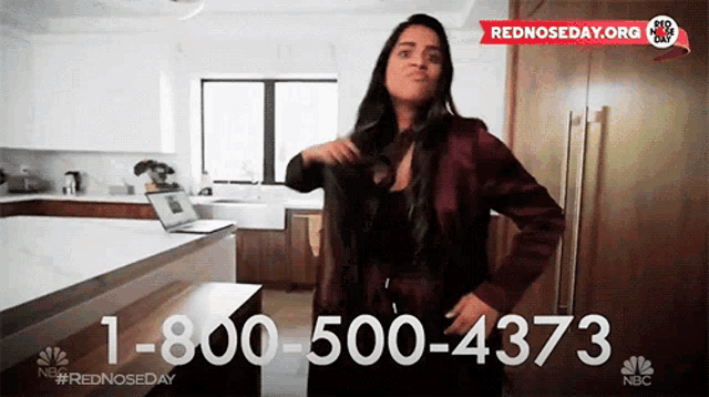 a woman is standing in a kitchen with a phone number for rednosed day