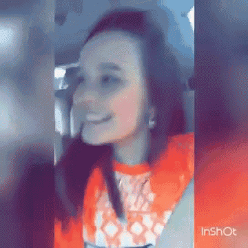 a woman is sitting in a car and smiling .