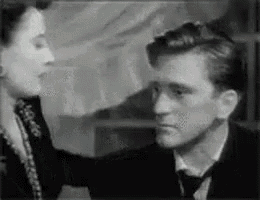 a man and a woman are standing next to each other in a room .