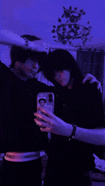 two people are taking a picture of themselves with their phones
