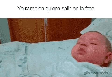 a baby is wrapped in a blanket with the words yo tambien quiero salir en la foto below it