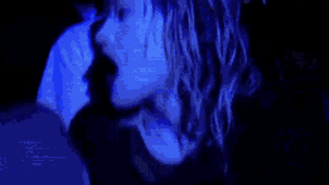 a person is laying in a dark room with a blue shirt on that says well rage .