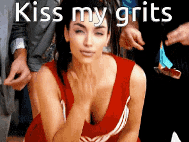 a woman in a red cheerleading uniform is being kissed by a man