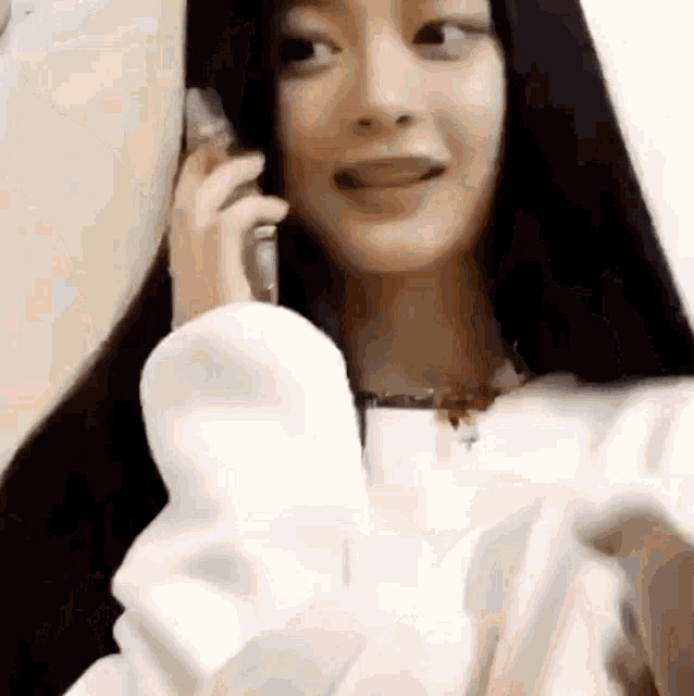 a woman is talking on a cell phone with her tongue out .
