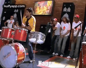 a man is playing drums in front of a group of men .