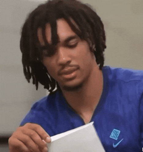 a man with dreadlocks is wearing a nike shirt