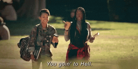 two women are walking down a sidewalk and one of them is saying `` you goin to hell '' .