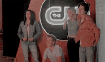a group of people standing in front of a sign that says the u.