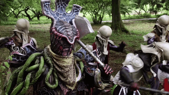 a group of people dressed up as monsters are standing in the woods