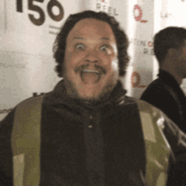 a man is making a funny face in front of a banner that says 150