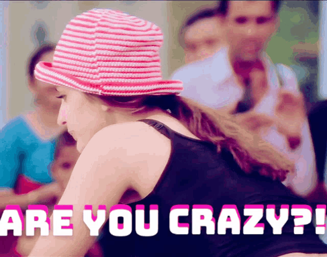 a woman wearing a pink and white hat and a black tank top with the words are you crazy
