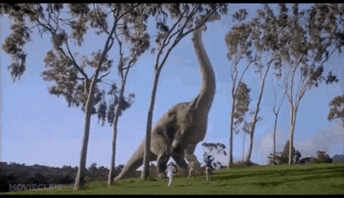 a giant dinosaur is standing in the middle of a field with trees .