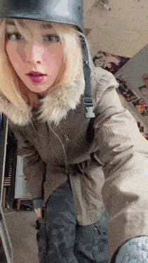 a woman wearing a helmet and a fur collared jacket