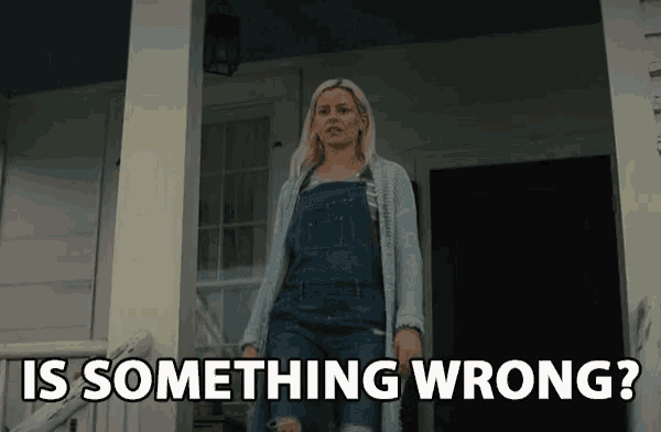 a woman in overalls stands on a porch with the words is something wrong below her
