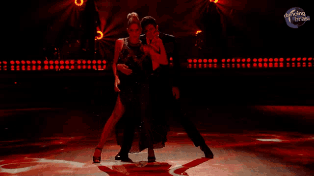 a man and a woman are dancing on a stage with dancing brasil in the background