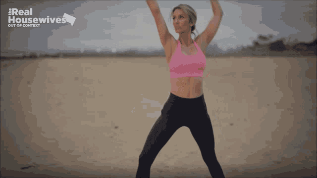 a woman is doing yoga on the beach in front of a real housewives sign