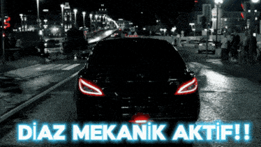 a black car is driving down a street at night with the words diaz mekanik aktif written above it