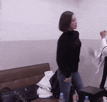 a woman in a black sweater is standing in a room
