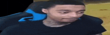 a man in a black shirt is sitting in a blue chair .