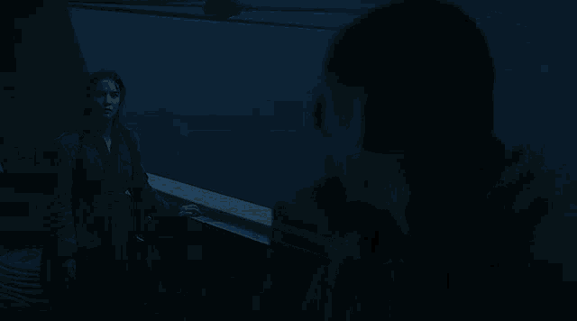 a woman is standing on a balcony looking out at the ocean