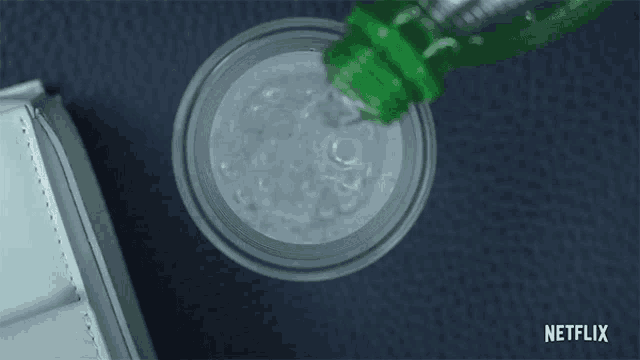 a bottle of sprite is being poured into a cup of ice .