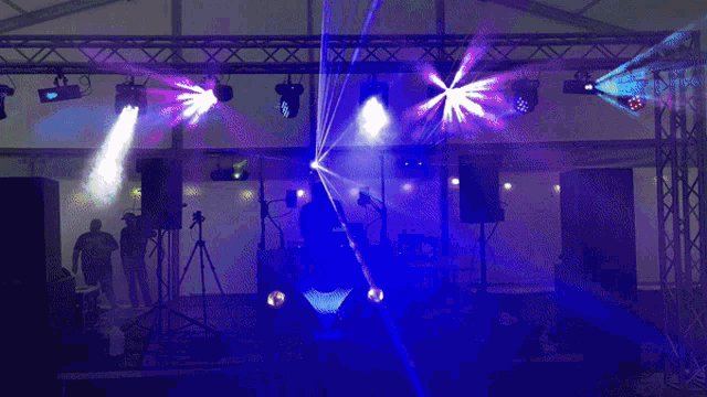 a man playing a dj set in a dark room with a lot of lights