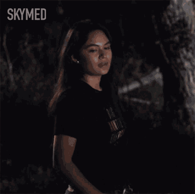 a woman in a black shirt says thank you in the dark