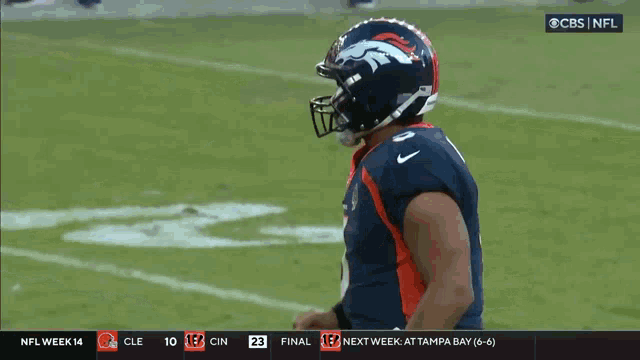 a broncos football player celebrates on the field during a game