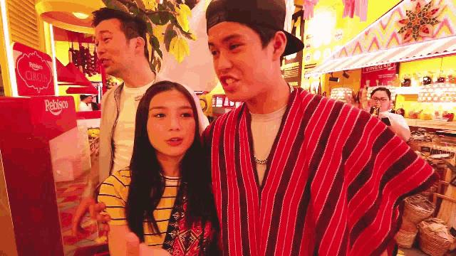 a man in a red and black striped shirt is standing next to a woman in a yellow shirt