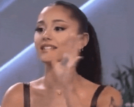 ariana grande is making a funny face while talking to a man .