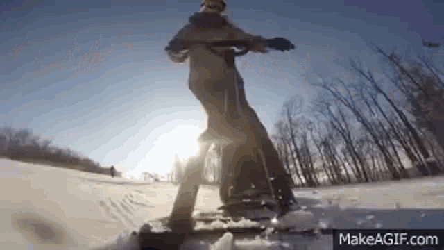 a person is riding a snowmobile in the snow on make a gif .
