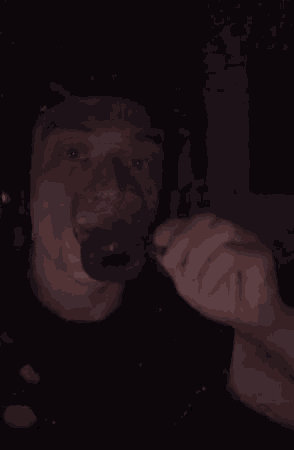 a man is wearing headphones and holding a lighter in his hand in the dark .