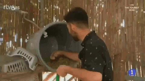 a man in a black shirt is holding a bucket of water
