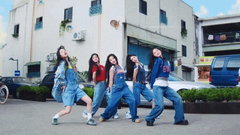 a group of young women are posing for a picture in front of a building with a sign that says sm on it