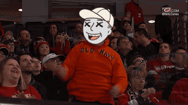 a crowd of people watching a hockey game with a man wearing a hurricanes shirt