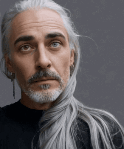 a man with long grey hair and a beard has a tattoo on his face
