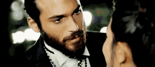 a man with a beard is looking at a woman .
