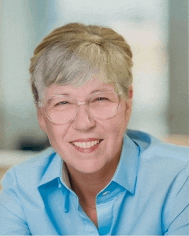 a smiling woman wearing glasses and a blue shirt